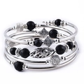 Bohemian multi-layer wrap bracelet featuring black volcanic lava beads and silver charms - Lava Stone Style