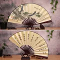 Chinese bamboo ink painting folding fan with calligraphy and a dark wooden display stand - 10-Inch Bamboo Announcing Peace