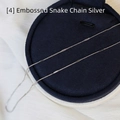 Detailopname van de zilveren reliëf slangenketting op een donkerblauwe juwelendoos - Reliëf Slangenketting / 45 cm / Zilver