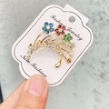 Broche tulipe dorée élégante avec strass colorés et perles sur carte de présentation - A7-22