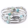 Detail of bohemian layered bracelets with turquoise, tiger eye stones and silver floral charms - Premium Amazonite Style