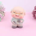 Figurine de gâteau grand-père avec lunettes dorées et théière sur fond rose doux - Ornement de grand-père en vinyle