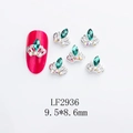 Detailed macro of silver crown nail art studs with green rhinestones on red nails - Crown-LF2936 / Silver/Green
