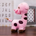 Pink plush giraffe toy with brown spots and soft fur on a wooden background surface - Light Pink / 25cm