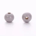Detailed macro view of two light grey wooden round beads with drill holes for DIY jewelry - Gray