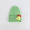 Dettaglio del cappello di Natale in maglia verde con campana gialla e fiocco rosso - Verde avocado