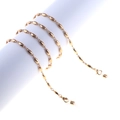 Minimalist gold metal glasses chain with oval beads wrapped on white display stand - Gold