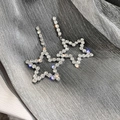 Detail van zilveren oorbellen met glinsterende sterren en hangende strass kettingen - Zilveren Strass Pentagram (925 Zilveren Pin)