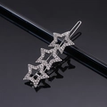 Macro shot of silver three-star hair clip with glittering rhinestones on dark background - Silver Three Pentagrams Rhinestone Frog Clip