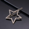 Macro shot of gold star hair clip with sparkling white rhinestones on black mirror - Gold Pentagram Rhinestone Frog Clip