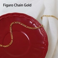 Detailed view of golden Figaro chain necklace with classic alternating links on ceramic - Figaro Chain / 50 cm / Gold