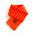 Short orange knitted scarf with a brown leather label detail on a white background - Neon Orange / 100-135