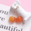 Detailed view of cherry drop earrings with orange gradient finish on a pink background - Standard Size / Orange Yellow