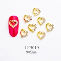 Macro shot of 9x9mm gold heart nail charms with white rhinestones and a red nail sample - Heart Shape (LF3019) / 1 Piece