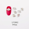 Macro shot of 9x6mm silver Saturn nail charms with AB rhinestones on a red nail sample - Silver AB Planet Style (LF3002)