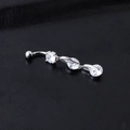 Macro shot of silver navel piercing ring with clear zircons on black background - Silver