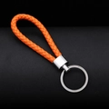 Portachiavi in pelle intrecciata arancione con anello in metallo argento su sfondo scuro - 30*1.6mm / Arancione