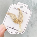 Golden wing brooch featuring sparkling rhinestones and a white pearl drop charm - A7-24