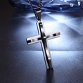 Close-up of dual-tone silver and black stainless steel cross pendant on textured surface - Silver & Black