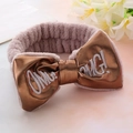 Close-up of plush brown headband with a gold PU bow featuring embroidered OMG letters - Khaki