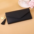 Detail of black long envelope wallet with gold heart pendant and elegant leather texture - Black