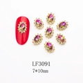 Macro view of oval iridescent crystal nail charms with small rhinestones and gold base - 3091 Purple Green Aurora Gold Base Oval (LF3091)