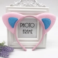 Close-up of pink and blue plush cat ear headband on a vintage white frame background - Pink with Blue Cat Ears