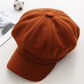 Detailed close-up of a caramel-colored wool newsboy cap on a stylish fashion magazine - M / Brown