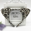Detail of plush leopard print cat ears headband on a white decorative photo frame - White Leopard Print Cat Ears