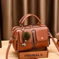 Brown faux leather Boston bag with dual pockets and a green pompom charm detail - Earthy Yellow