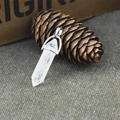 Hexagonal white crystal pendant with silver clasp on natural green background - Natural Clear Quartz