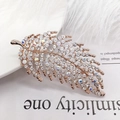 Elegante spilla a foglia oro rosa con cristalli bianchi e strass iridescenti - Piuma con diamanti