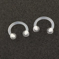 Detail of two transparent acrylic horseshoe piercings with screw balls on black surface - Horseshoe Nose Ring (Single)