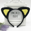 Detail of plush black cat ears headband with yellow inner lining on a photo frame - Black with Yellow Cat Ears