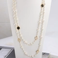 Long double-layer pearl necklace with elegant black and gold camellia flower pendants - White