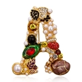 Broche de letra A dorado con strass de colores, perlas blancas y detalles de esmalte café - Letra A