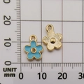 Blue enamel flower pendant and golden textured charm on a millimeter scale grid - Lake Blue Enamel Flower