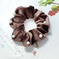 Brown velvet scrunchie with pearls on a decorative background with leaves - Khaki with Pearl