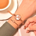Elegant rose gold women's watch with chain strap and matching star bracelet on wrist - Pink Dial