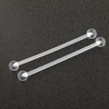 Close-up of two transparent acrylic barbell body piercing studs on a matte black surface - 38mm Long Industrial Barbell (Single)