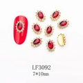 Close-up of red oval crystal nail charm with white rhinestones and gold metal base - 3092 Bright Red Gold Base Oval (LF3092)