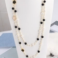 Elegant double-layer pearl necklace featuring black and white camellia charms and gold chain - Black
