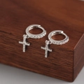 Makro-Detail von silbernen Kreuz-Ohrringen mit funkelndem Cubic Zirkonia Pavé - Weißgold