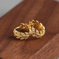 Elegante goldene Olivenblatt-Ohrringe mit Kristallen auf dunkler Holzoberfläche - Goldfarbe (Paar)