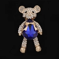 Detailed close-up of golden bear brooch with blue crystal and shimmering white rhinestones - Sapphire Blue