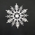 Detailed top-down view of a white plastic snowflake ornament on a black background - 12-Petal 10cm White Snowflake