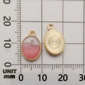 Pink and white gradient oval pendant with gold metal frame on measuring grid paper - Lake Blue Bow Small