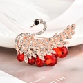 Elegante spilla a cigno in oro rosa con cristalli bianchi e pietre rosse a goccia - Cigno nobile rosso