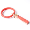 Detail showing red textured leather wristlet keychain with gold metal ring and tassel - Red