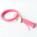 Detailed view of pink leather O-ring keychain with golden hardware and fringe tassel - Rose Red